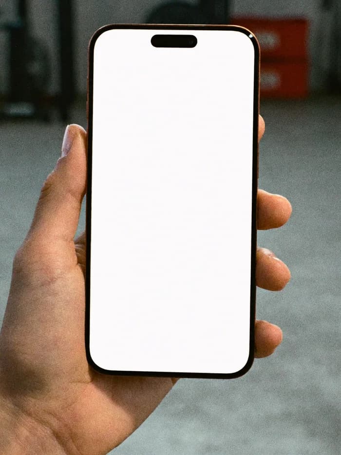 A hand holding a phone with the FORMA website open on it