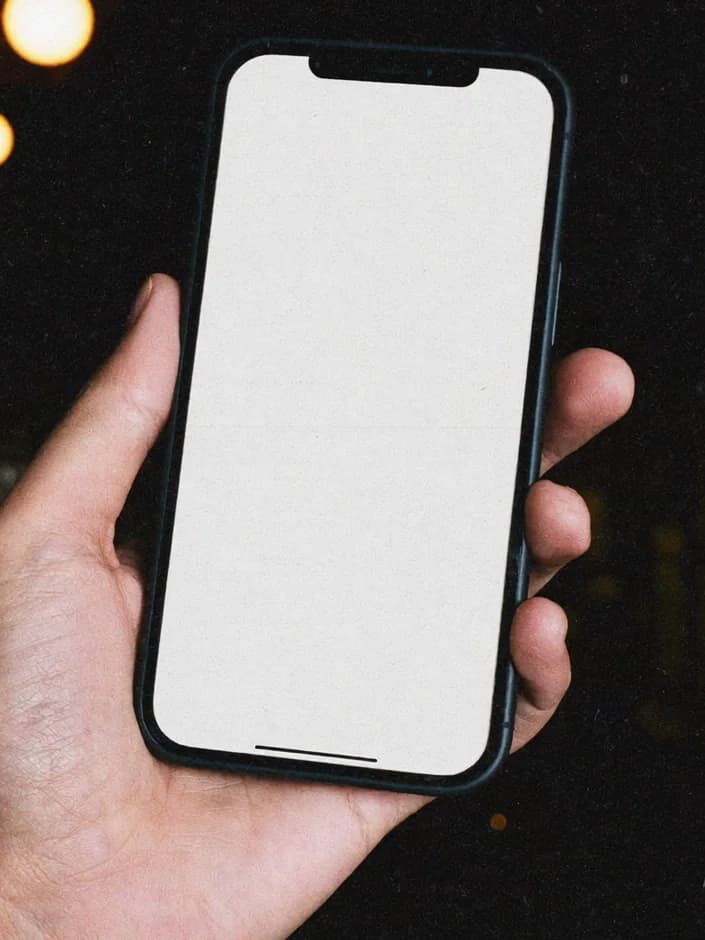 A hand holding a phone with the LUMEN website open on it